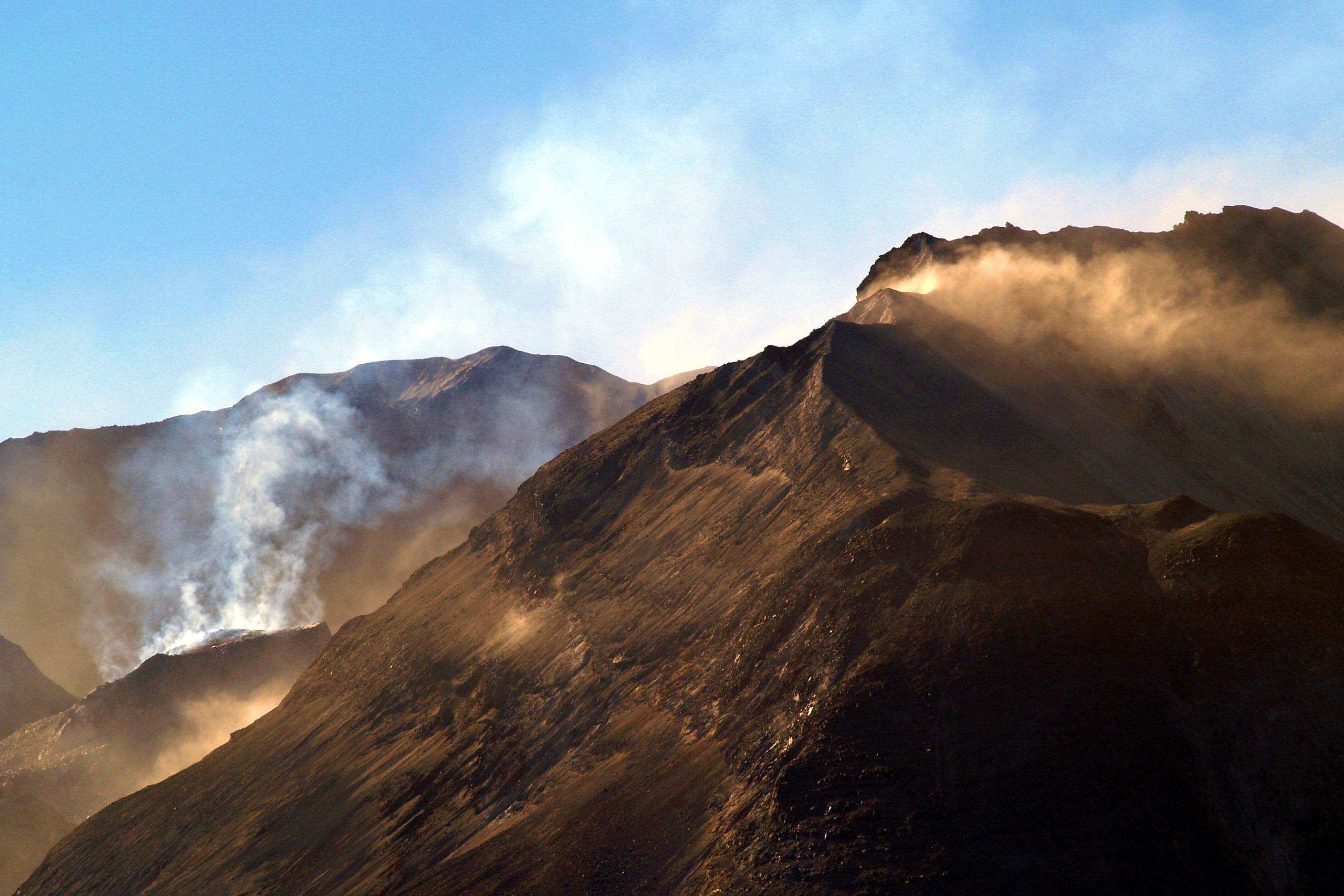 Mount St. Helens with its steaming lava dome under a blue sky